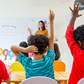 Kids in classroom raising hands.